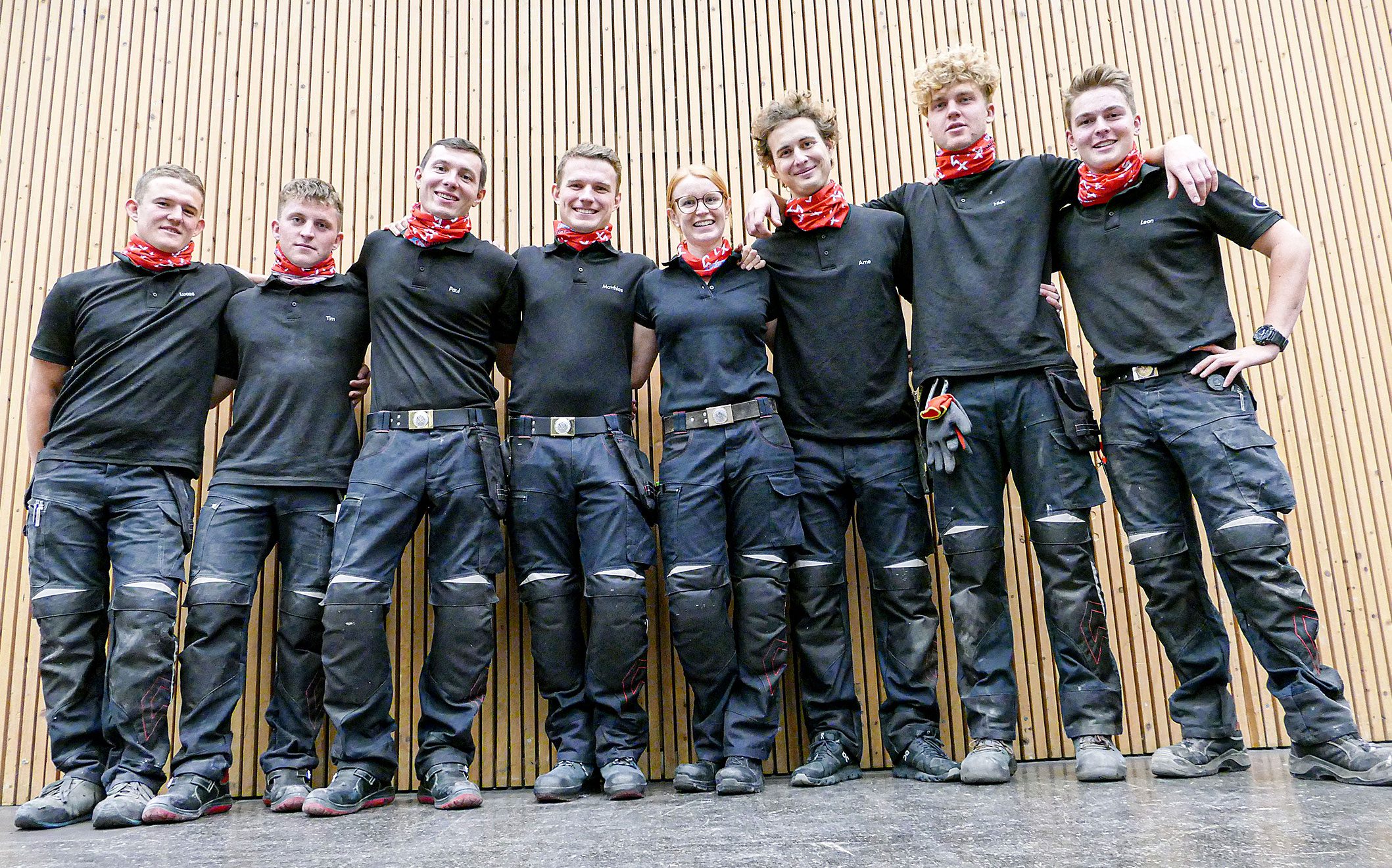 Dachdecker Nationalteam steht in Heldenpose dicht nebeneinander